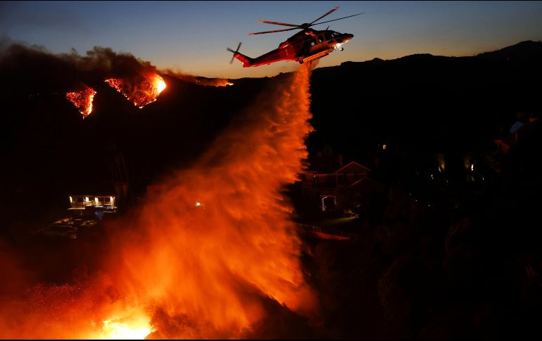 Mansiones en Los Ángeles se encuentran en llamas; helicópteros en el cielo lanzan cargas de agua para combatir el incendio forestal. EFE / EPA / CAROLINE BREHMAN