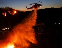 Mansiones en Los Ángeles se encuentran en llamas; helicópteros en el cielo lanzan cargas de agua para combatir el incendio forestal. EFE / EPA / CAROLINE BREHMAN