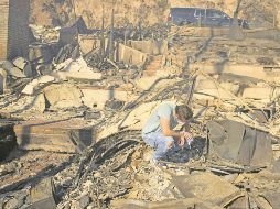 Habitantes de las zonas siniestradas regresan a sus hogares, en cenizas. AP