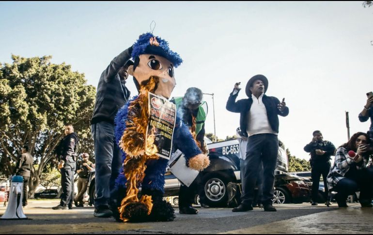 Activistas queman una piñata durante una manifestación, a manera de protesta por los abusos que algunos agentes de seguridad cometen en contra de migrantes. EFE