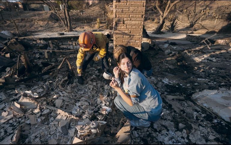 Una vecina sostiene una de las pocas pertenencias que quedaron tras el incendio de su hogar: una taza. AP