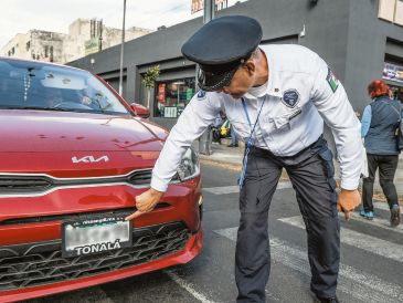 Oficial de la Policía Vial muestra el código QR que no debe ser tapado por el portaplacas. EL INFORMADOR/A. Navarro