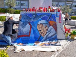 El pintor mexicano Roberto Márquez colocó un retrato del Papa Francisco afuera del Hospital Gemelli de Roma. AP