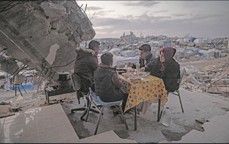 Una familia palestina come en lo que queda de su hogar en Gaza, enclave que ahora sufre de falta de electricidad. EFE