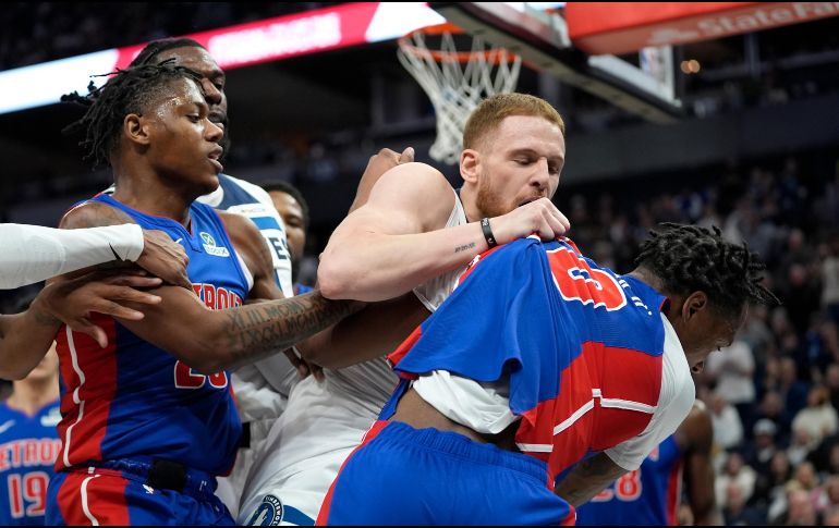 Donte DiVincenzo de los Timberwolves de Minnesota pelea con Ronald Holland II de los Pistons de Detroit. AP Photo / ARCHIVO