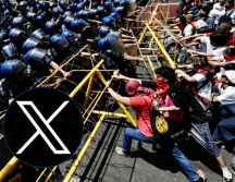 En Manila, Filipinas, manifestantes intentan retirar una barrera ante la policía antidisturbios durante la manifestación del Día Internacional del Trabajo, este jueves. EFE / F. R. MALASIG