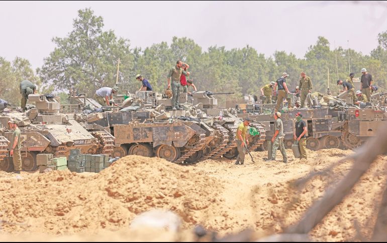 Soldados israelíes trabajan en sus vehículos blindados cerca de la frontera con Gaza. El Ejército anunció la expansión de su ofensiva para liberar rehenes y derrotar a Hamás. AFP