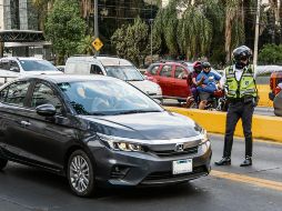 Un agente vial regula el paso en la glorieta, ante la presión de conductores impacientes por avanzar. EL INFORMADOR/A. Navarro