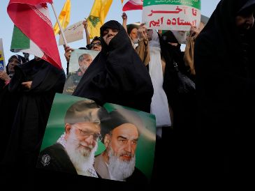 Una mujer iraní sostiene un cartel del ayatolá Jomeini, el fallecido líder revolucionario iraní, a la derecha, y el actual líder supremo, el ayatolá Alí Jamenei. AP / V. Salemi