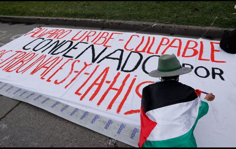 Una persona realiza un cartel contra el expresidente Álvaro Uribe este viernes, frente al Complejo Judicial de Paloquemao en Bogotá (Colombia). EFE / M. Dueñas
