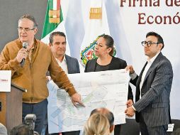 Marcelo Ebrard señala un plano con la distribución que tendrá el clúster en Puebla, que también impulsará la vivienda en la zona. ESPECIAL