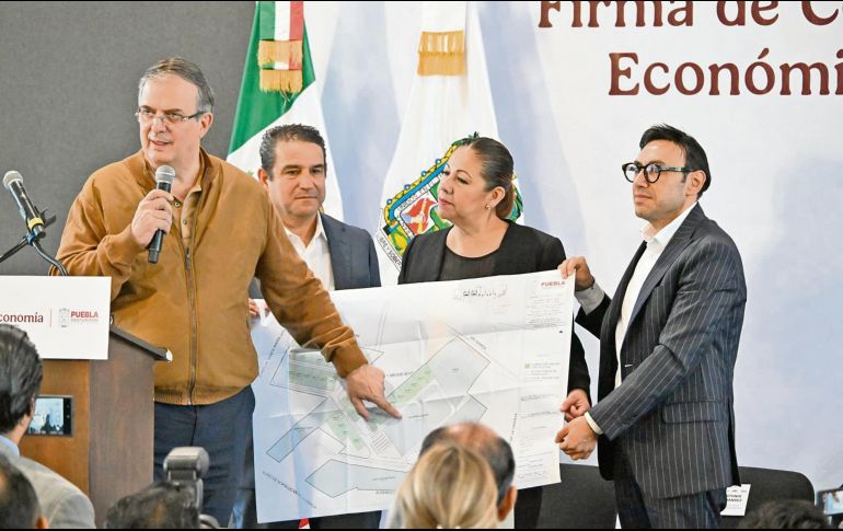 Marcelo Ebrard señala un plano con la distribución que tendrá el clúster en Puebla, que también impulsará la vivienda en la zona. ESPECIAL