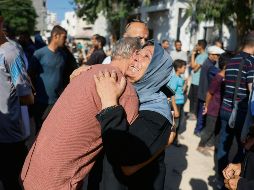 Una mujer llora a sus familiares fallecidos tras el más reciente bombardeo israelí sobre Gaza. AFP