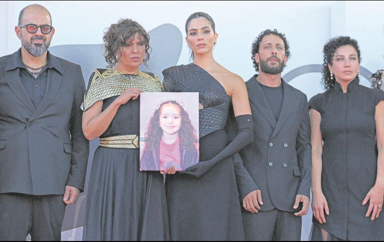 El actor israelí Amer Hlehel, la directora tunecina Kaouther Ben Hania, la actriz Saja Kilani, el actor Motaz Malhees y la actriz Clara Khoury posan con un retrato de la fallecida niña palestina Hind Rajab durante la alfombra roja de la película “La voz de Hind Rajab”. AFP