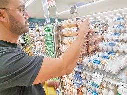 Un consumidor selecciona huevos frescos en un supermercado de Jalisco, destacando la importancia del producto líder en la producción nacional y su aporte nutricional diario. EL INFORMADOR