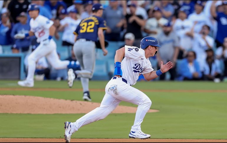 Tommy Edman corre después de batear un hit, al fondo Will Smith va hacia home para marcar la carrera de la victoria. EFE/A. Dinner