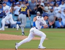 Tommy Edman corre después de batear un hit, al fondo Will Smith va hacia home para marcar la carrera de la victoria. EFE/A. Dinner