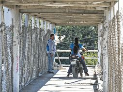 En el puente de la Carretera a Chapala y Guadalupe Montenegro, motociclistas invaden el espacio destinado a los peatones, poniendo en riesgo su seguridad. Mientras tanto, autoridades federales, estatales y municipales se deslindan y se pasan la bolita. Nadie sanciona. EL INFORMADOR/ J. Acosta