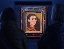 Los visitantes observan la pintura de Frida Kahlo titulada 