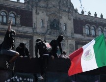 Manifestantes trepan por una valla en inmediaciones del Palacio Nacional en Ciudad de México (CDMX). EFE/J. Méndez