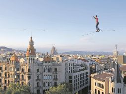 El artista francés Nathan Paulin camina sobre una cuerda en la Plaza de Cataluña, en Barcelona, como parte del Festival Grec, en julio de 2023. AFP/L. Gene