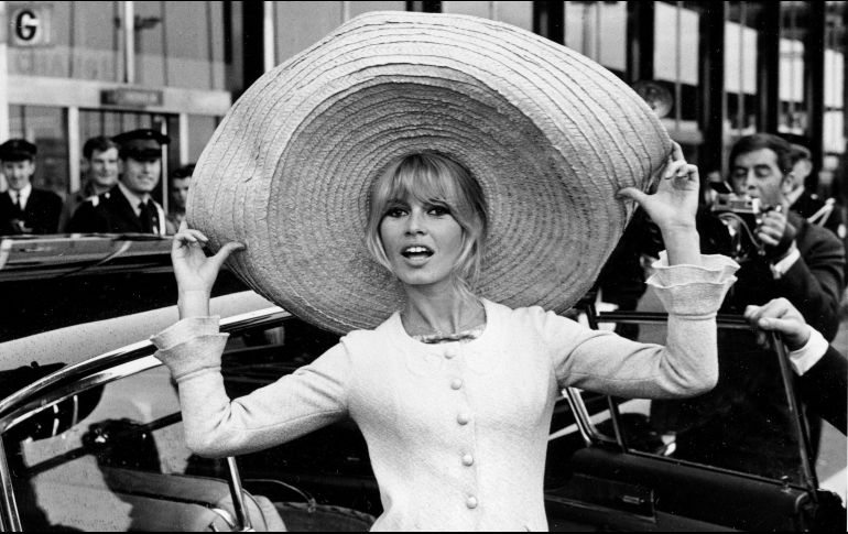 Brigitte Bardot posa con un enorme sombrero que trajo de México, a su llegada al aeropuerto de OrlY, el 27 de mayo de 1965, en París, Francia. AP