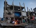 Desplazados palestinos junto a un fuego en los restos de un edificio en Kah Yunis. EFE / EPA / HAITHAM IMAD