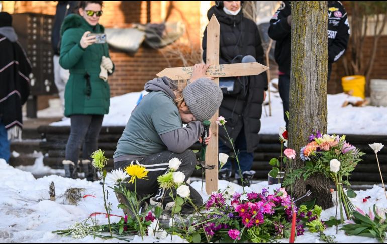 Una mujer ora en un monumento improvisado en el lugar en el que una mujer fue asesinada a tiros por un agente de Inmigración y Control de Aduanas (ICE) en Minneapolis, Minnesota. EFE / EPA / CRAIG LASSIG