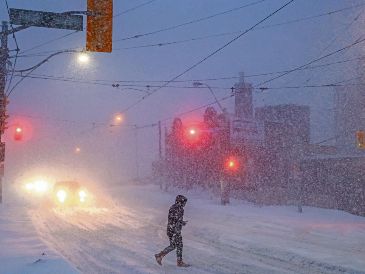 Personas caminan por el centro de Toronto, mientras una tormenta invernal atraviesa la región. AP