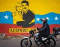 Una persona transita frente a un mural del presidente de Venezuela, Nicolás Maduro, y su esposa, Cilia Flores, en Caracas. EFE/R. Peña