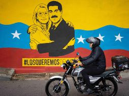 Una persona transita frente a un mural del presidente de Venezuela, Nicolás Maduro, y su esposa, Cilia Flores, en Caracas. EFE/R. Peña