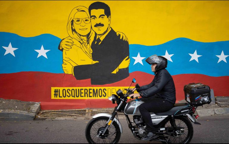 Una persona transita frente a un mural del presidente de Venezuela, Nicolás Maduro, y su esposa, Cilia Flores, en Caracas. EFE/R. Peña