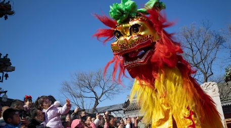 BEIJING (China), 17/02/2026.- Attendees look at performers taking part in a lion dance at the Dongyue Temple on the day of the Chinese Lunar New Year in Beijing, China, 17 February 2026. The Chinese New Year, also known as Lunar New Year, begins on 17 February, ushering in the Year of the Fire Horse with festivities running during the Spring Festival until the Lantern Festival on 03 March. EFE/EPA/ANDRES MARTINEZ CASARES