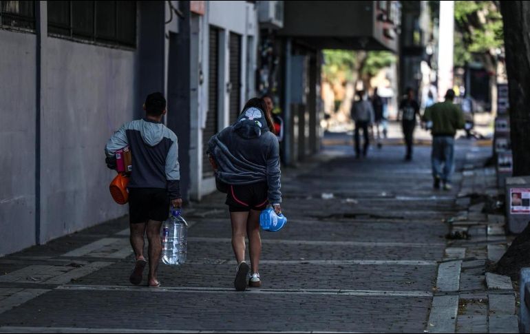 Andar con cautela. Tapatíos recorren el Centro de la ciudad cargando víveres, en un ambiente en el que reina la incertidumbre tras los hechos de ayer domingo en Tapalpa y los bloqueos en puntos de Jalisco y el AMG. EL INFORMADOR / A. Navarro
