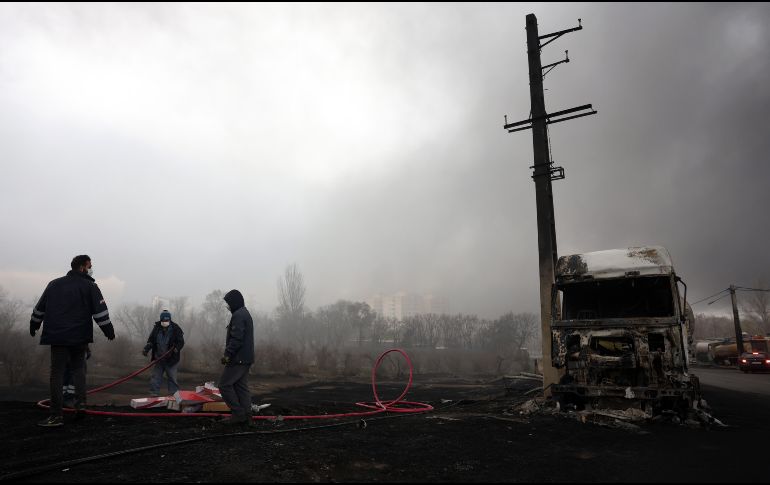 Los iraníes trabajan mientras aún sale humo de la refinería de petróleo de Shahran tras el ataque aéreo de anoche en Teherán, Irán, 8 de marzo de 2026.  EFE/A. TAHERKENAREH