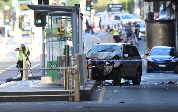 A white SUV (C) sits in the middle of the road as police and emergenc - A white SUV (C) sits in the middle of the road as police and emergency personnel work at the scene of where a car ran over pedestrians in Flinders Street in Melbourne on December 21, 2017. The car ploughed into a crowd in Australia's second-largest city on December 21 in what police said was a 