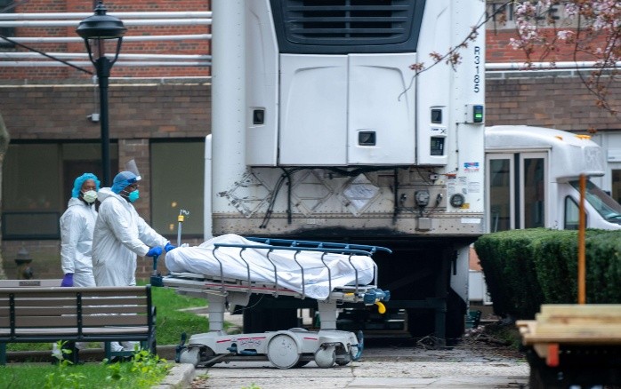 NEW YORK, NY - APRIL 8: Kingsbrook Jewish Medical Center employees transport a deceased patient to a refrigerated truck on April 8, 2020 in the Brooklyn borough of New York City. One of the city's hardest impacted hospitals due to the coronavirus (COVID-19), Kingsbrook has begun storing the bodies of the the deceased in refrigerated trucks.   David Dee Delgado/Getty Images/AFP== FOR NEWSPAPERS, INTERNET, TELCOS & TELEVISION USE ONLY == US-CORONAVIRUS-PANDEMIC-CAUSES-CLIMATE-OF-ANXIETY-AND-CHANGING-R-== FOR NEWSPAPERS, INTERNET, TELCOS & TELEVISION USE ONLY ==